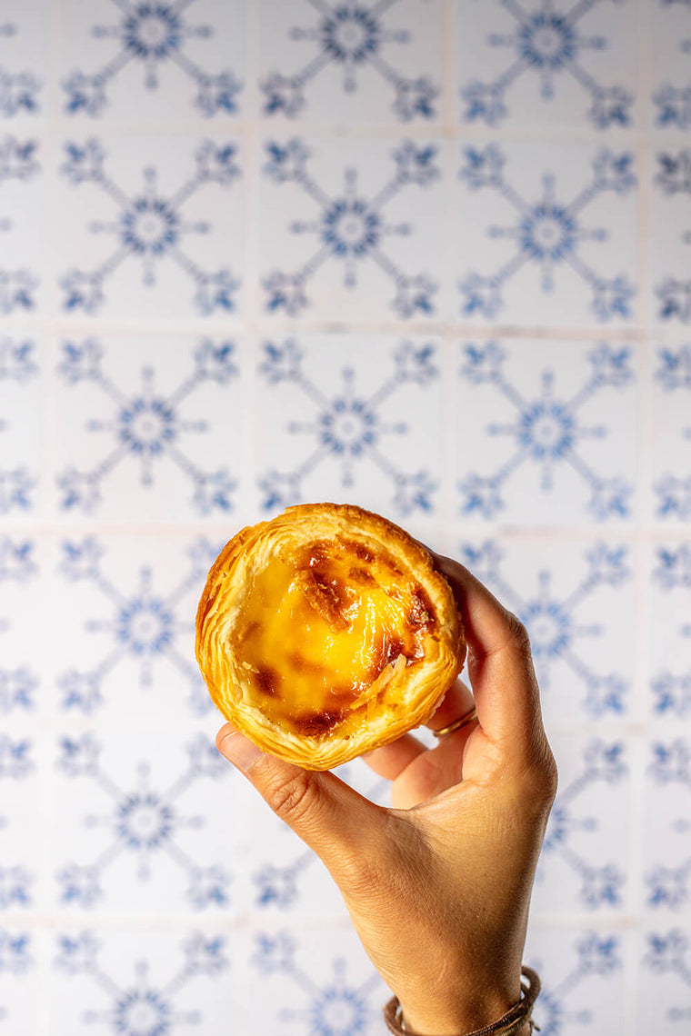 Blue azulejo photo backdrop featuring a pastel de nata, the iconic pastry from Lisbon, Portugal.