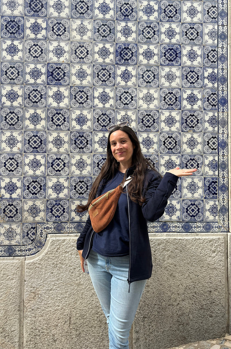 Photographer and creator of photo backdrops in Lisbon, Portugal, surrounded by blue azulejo tiles.