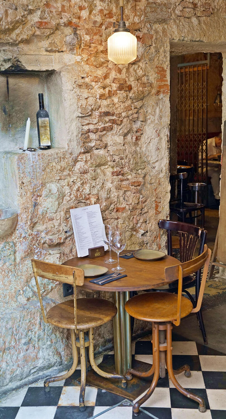 An authentic café restaurant in Lisbon with a warm Dolce Vita atmosphere, natural stone walls and Mediterranean charm.